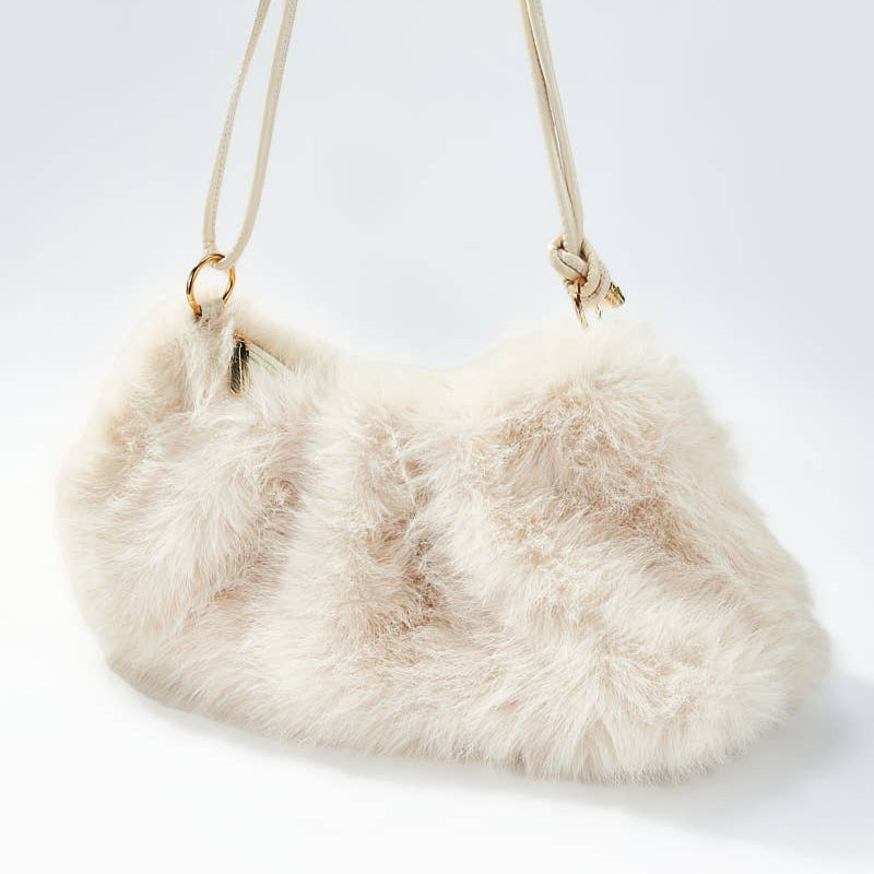 Fluffy beige handbag with a strap on a light gray background