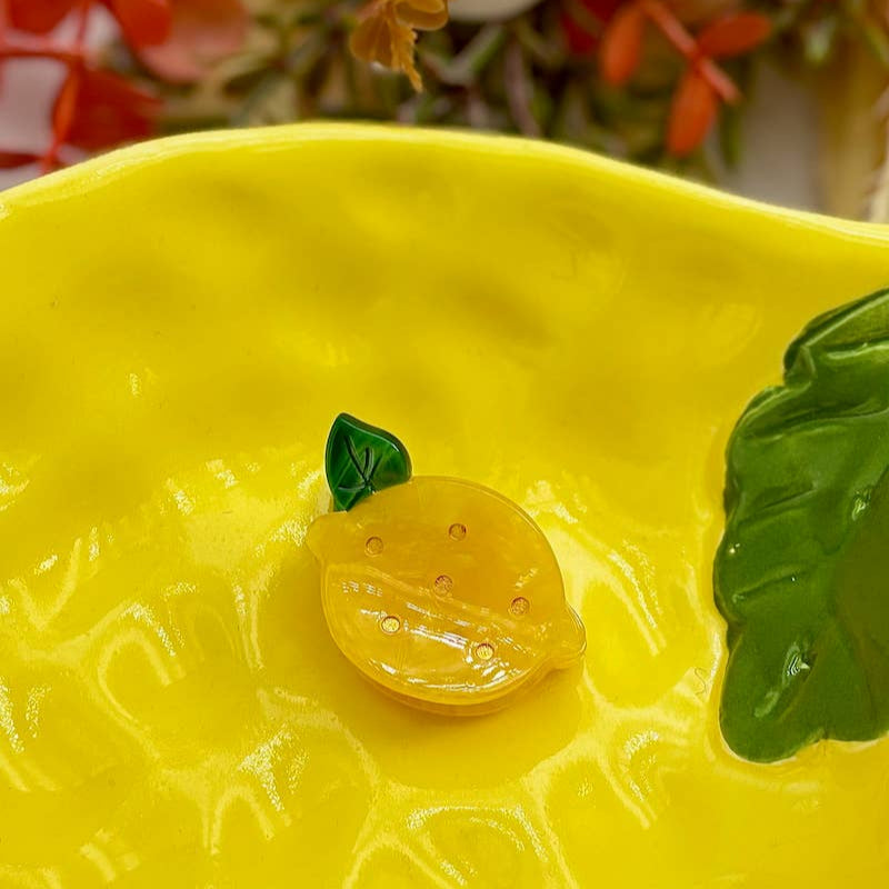 Yellow ceramic bowl with a lemon design on a blurred floral background