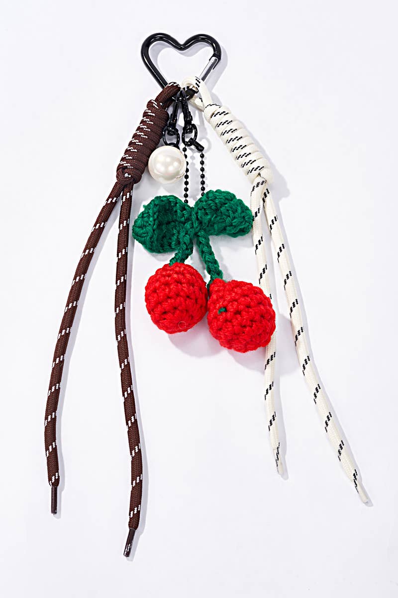Crochet keychain with red cherries, green leaves, and a heart-shaped clip 